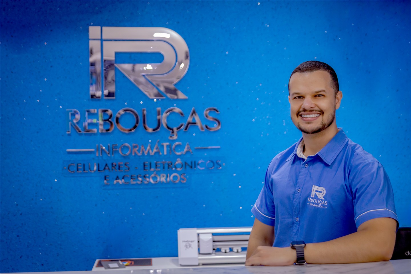 Profissional da Rebouças no balcão de atendimento, ao lado do logotipo da loja